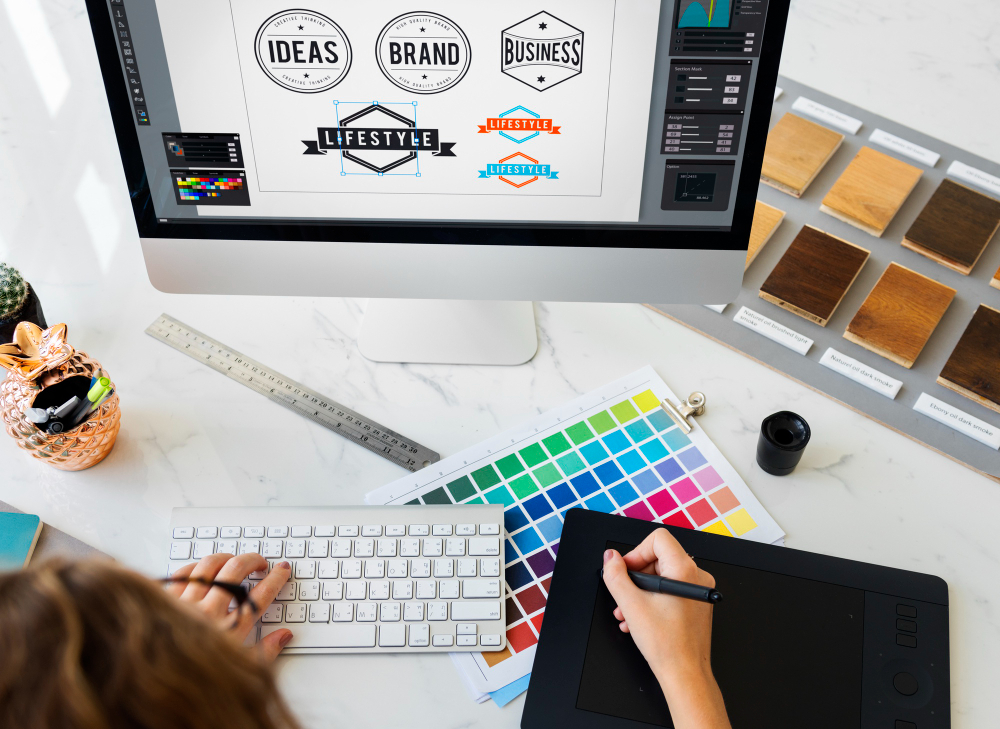 Logo design in progress for a UAE business, with a designer sketching brand marks beside colour and typography references